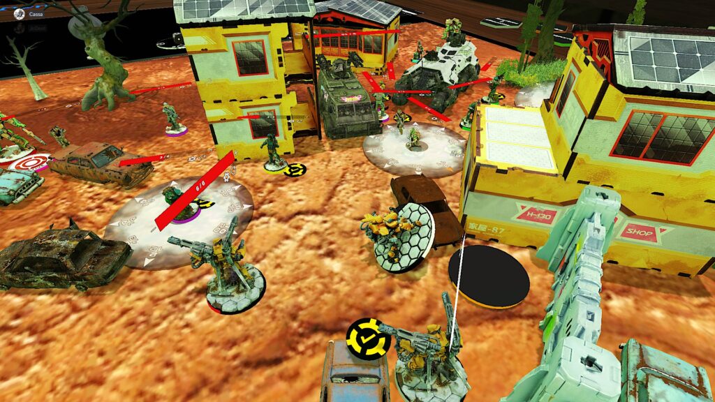 TTS screenshot: a desert mat strewn with infinity buildings and miniatures. Two miniatures have smoke markers centered on them. 