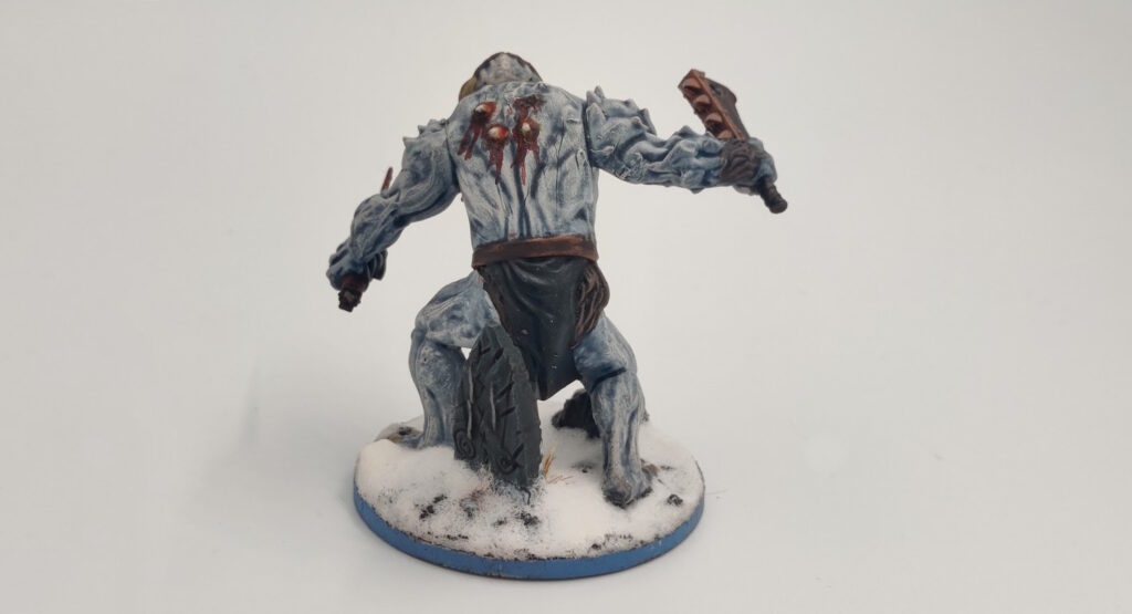 Mantic "Butcher": the skin is pale, blueish white, both arms are normal, the loincloth sports the raven banner, it has a blonde bear, and the headcover is leather with an red eye painted on it. The knife and the axe have died blood effects. There are plinths and stuff on the base. 