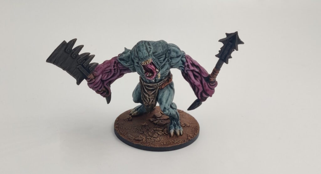 Mantic Butcher, front. Gray body, pink veiny arms, brown loincloth. 