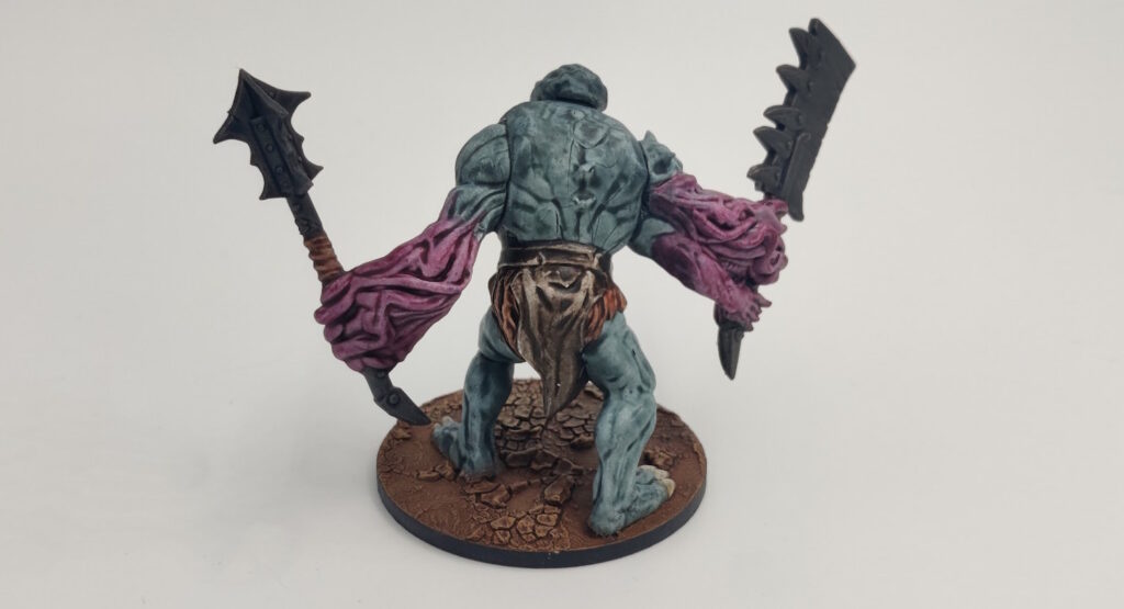 Mantic Butcher, front. Gray body, pink veiny arms, brown loincloth.