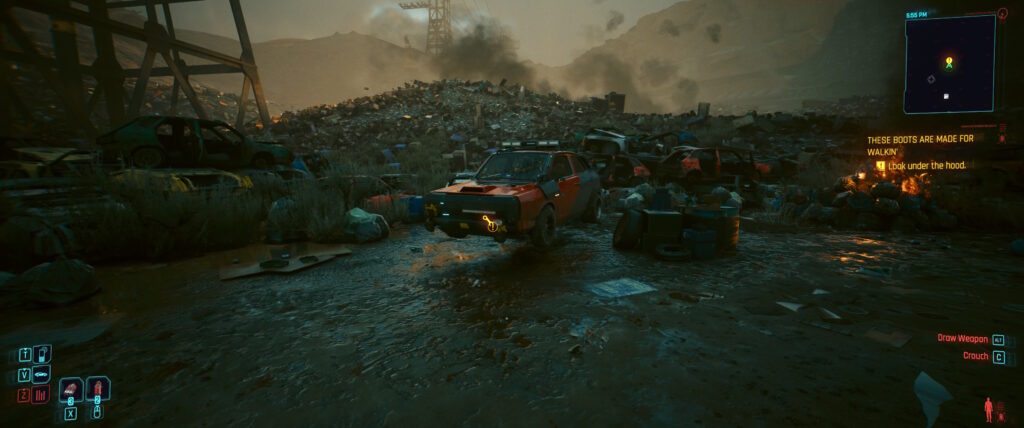 Cyberpunk 2077 screenshot: a junkyard. Our objective is a car in front of us. It's floating slightly above the ground. 