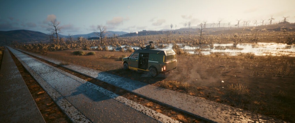 Cyberpunk 2077 screenshot:  a TV van rides between a concrete road and some waterlogged flats